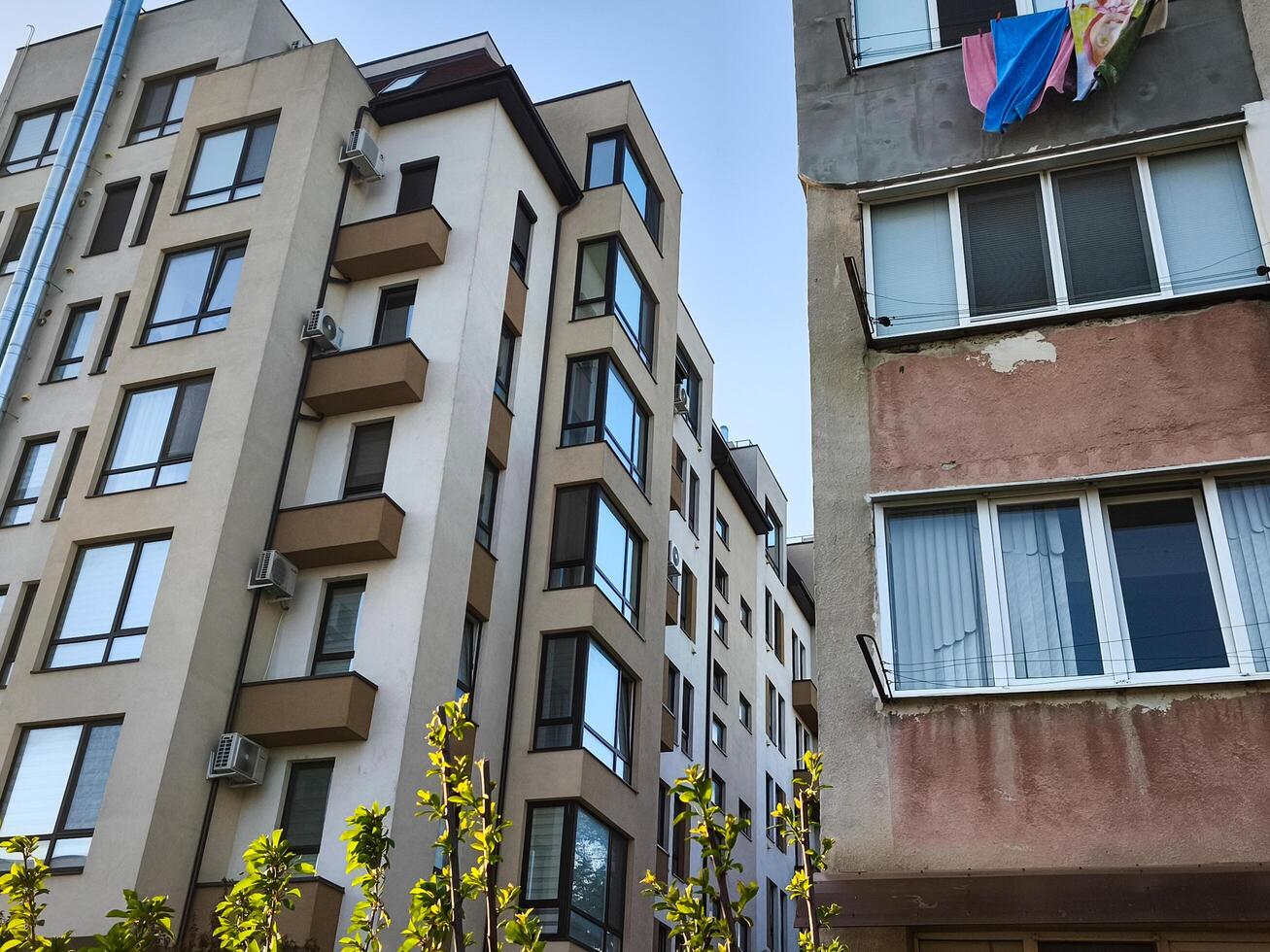 A building with a balcony and a large window. The building is tall and has a lot of windows photo