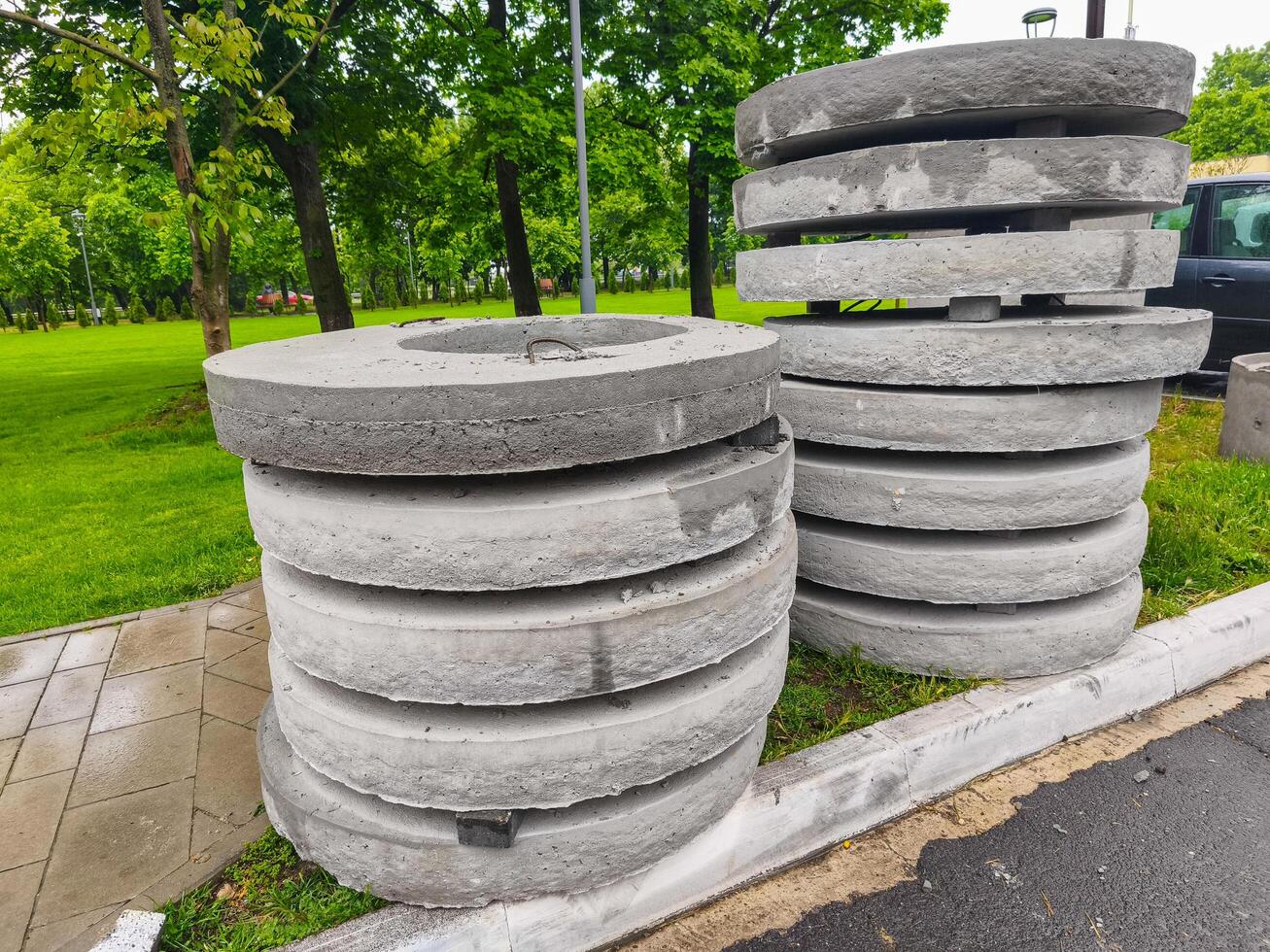 A pile of gray concrete blocks sits on the sidewalk. The blocks are stacked in a way that they are almost touching the curb. The scene is quiet and peaceful, with no people or vehicles in the area photo