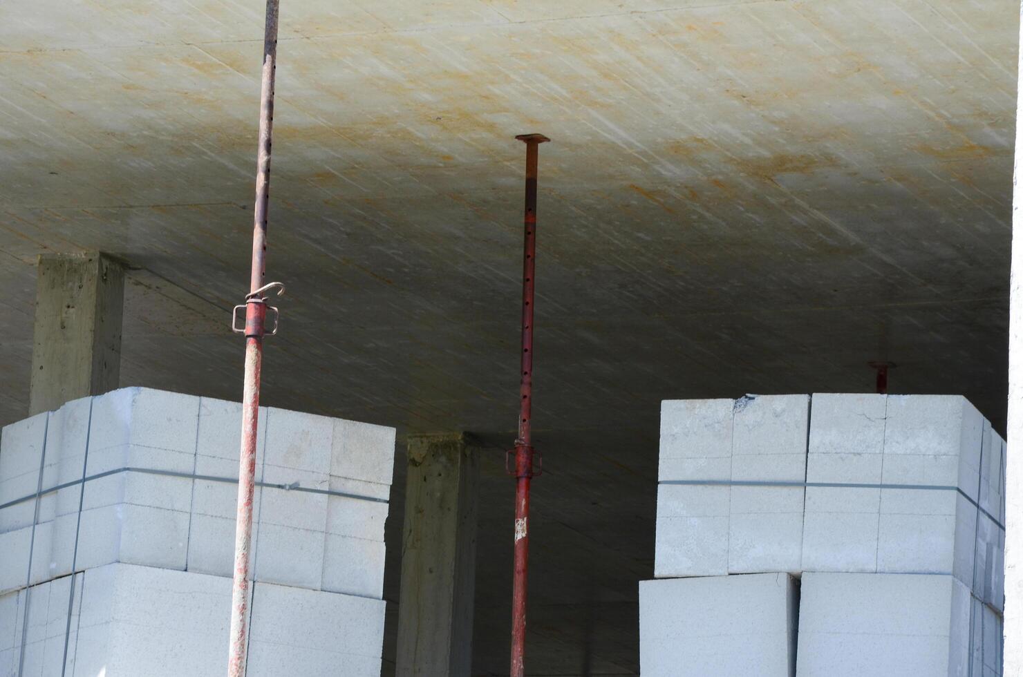 A construction site with a pile of white blocks and red poles. Scene is one of hard work and progress photo