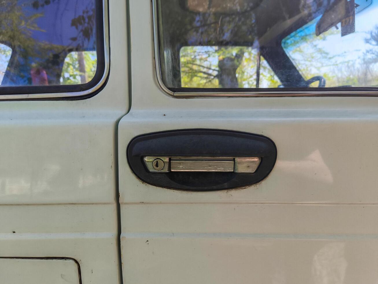 A white car with a black handle on the door. photo