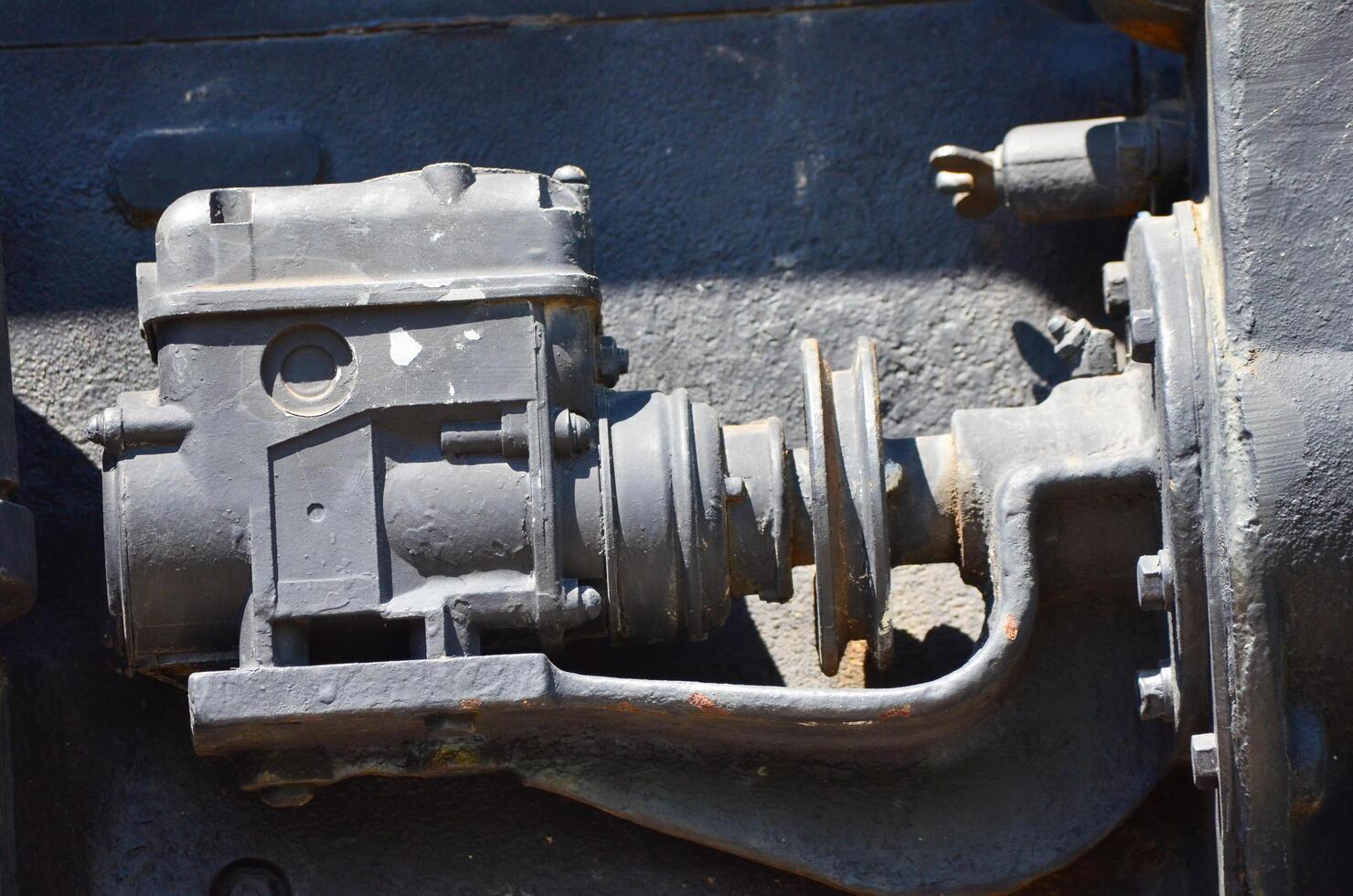 A black engine part with a white circle on it. The engine part is old and rusty photo