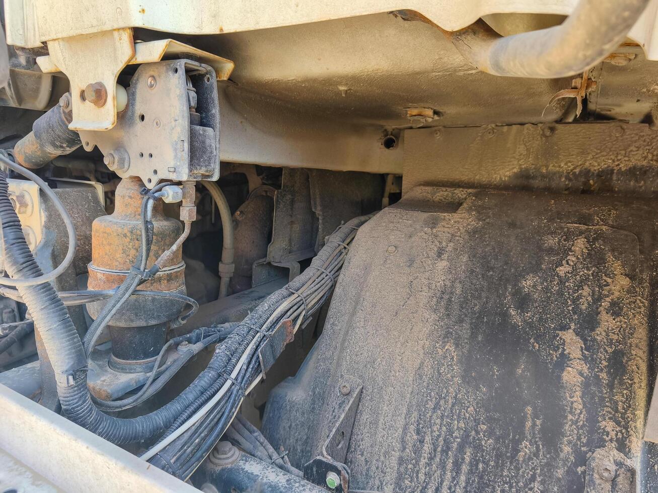 A dirty truck engine with a lot of wires and a lot of dirt. The engine is old and rusty photo