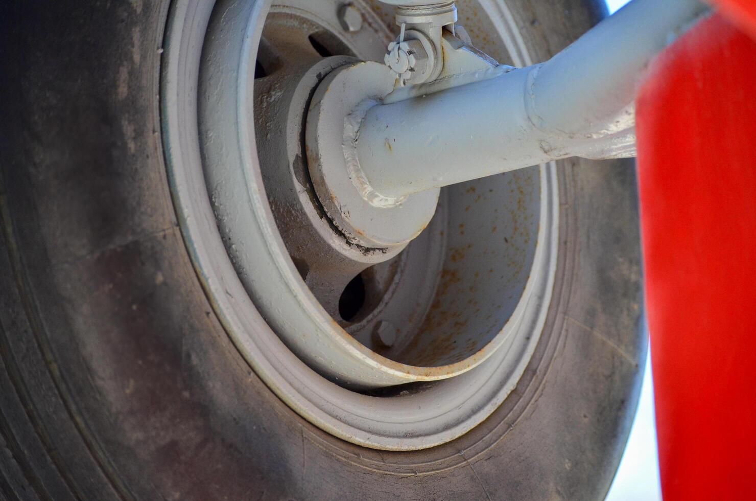 A tire with a red cloth draped over it. The tire is old and worn photo