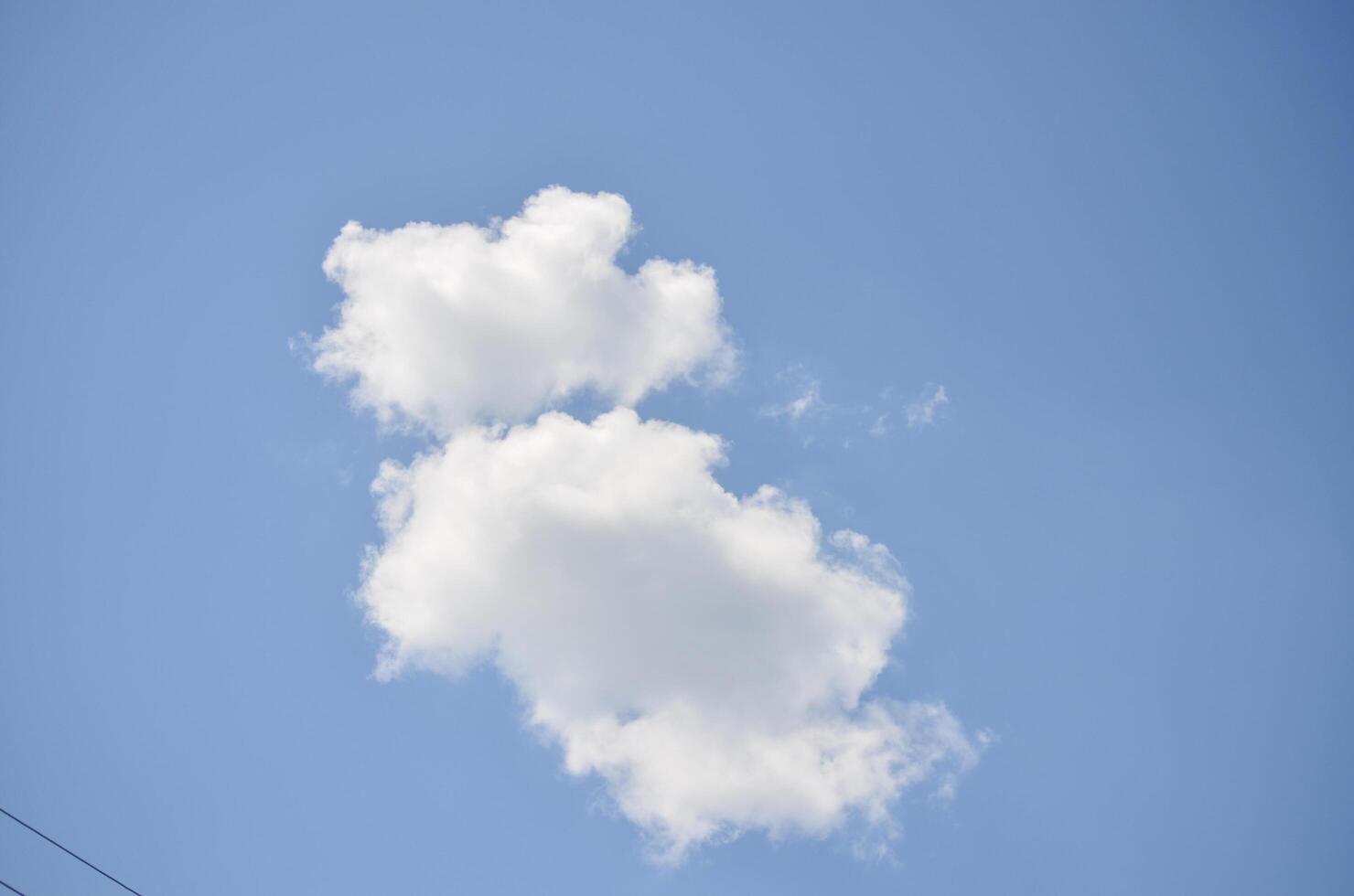 A cloud in the sky with a blue sky background. The cloud is shaped like a person. The sky is clear and bright photo