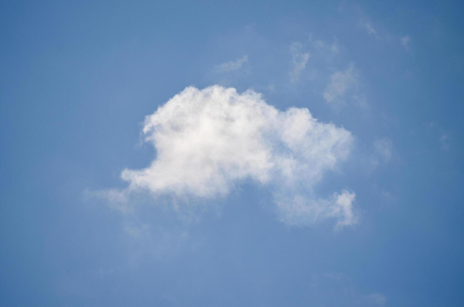 A cloudless blue sky with a single cloud. The cloud is white and fluffy. The sky is clear and bright photo