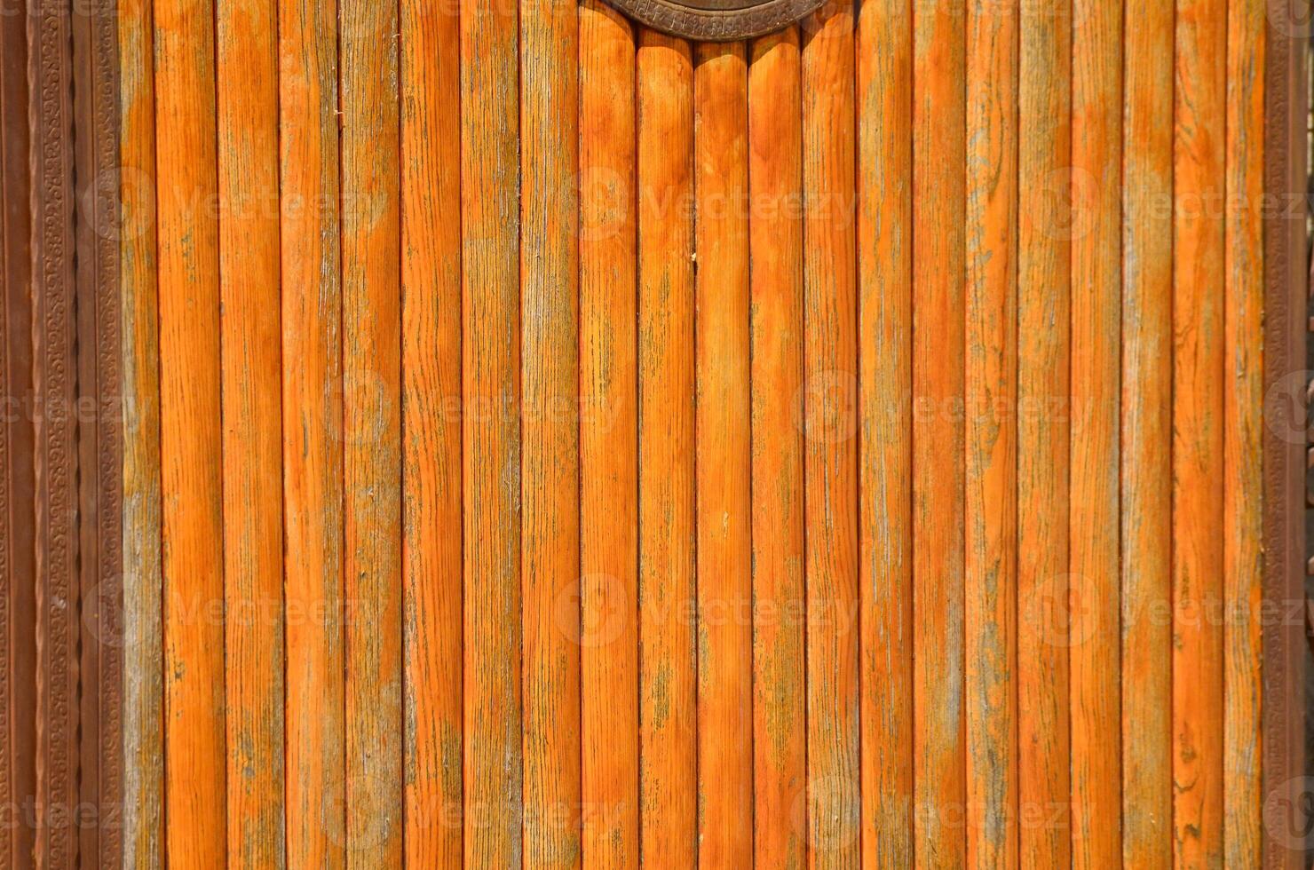 The wooden door has a rustic look to it. The wood is weathered and has a brownish tint. The door is open, revealing a view of the inside photo