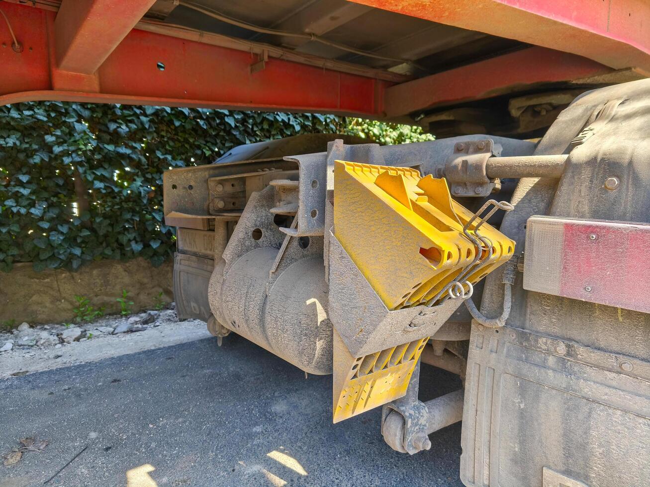 A yellow and red truck with a yellow and red bucket on the back. The bucket is attached to the back of the truck and is used for dumping photo