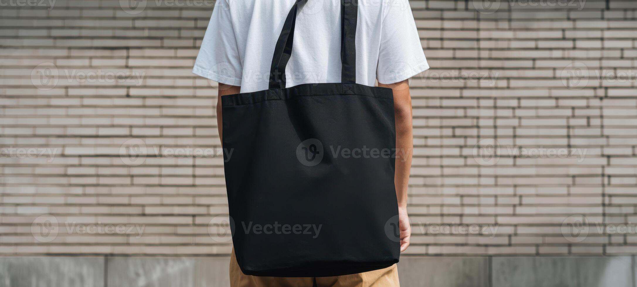 The stylish black tote bag on a casual man in an urban setting. photo