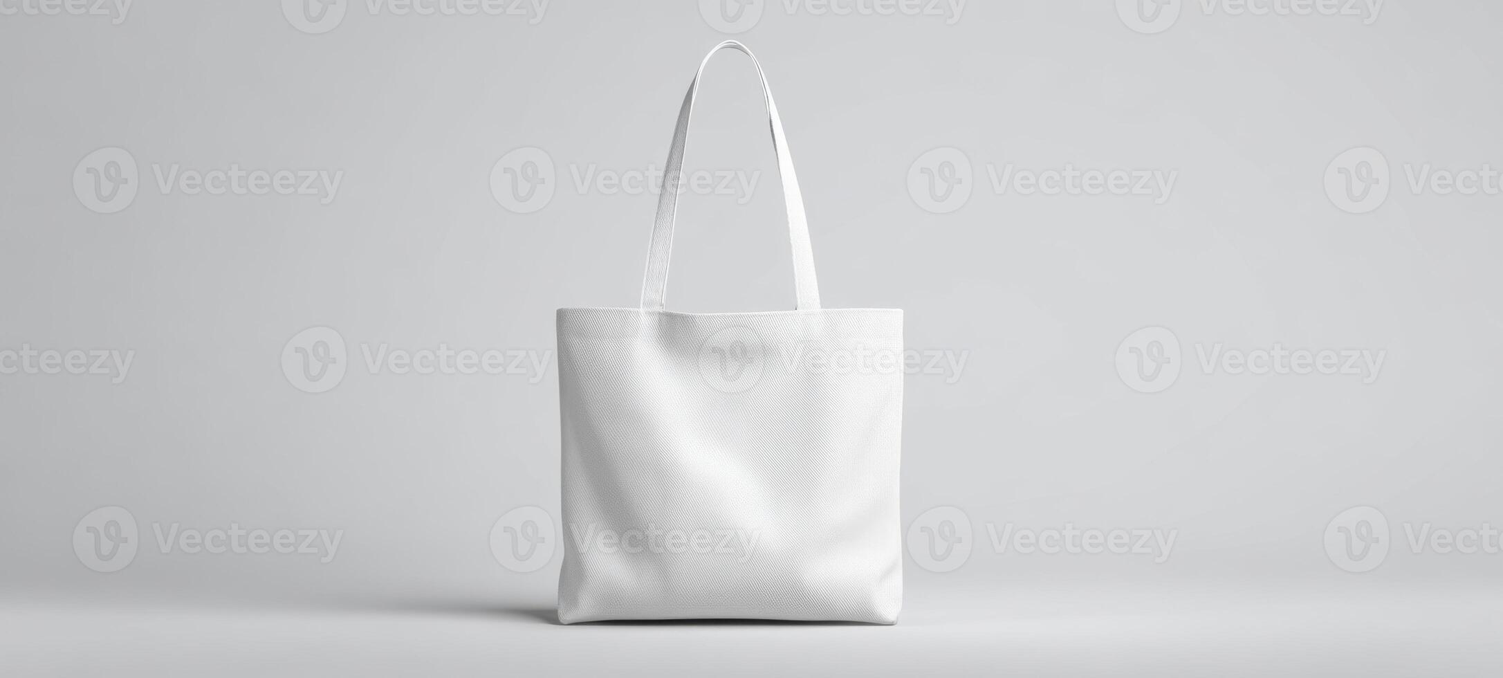 The minimalist white tote bag on a simple gray background. photo