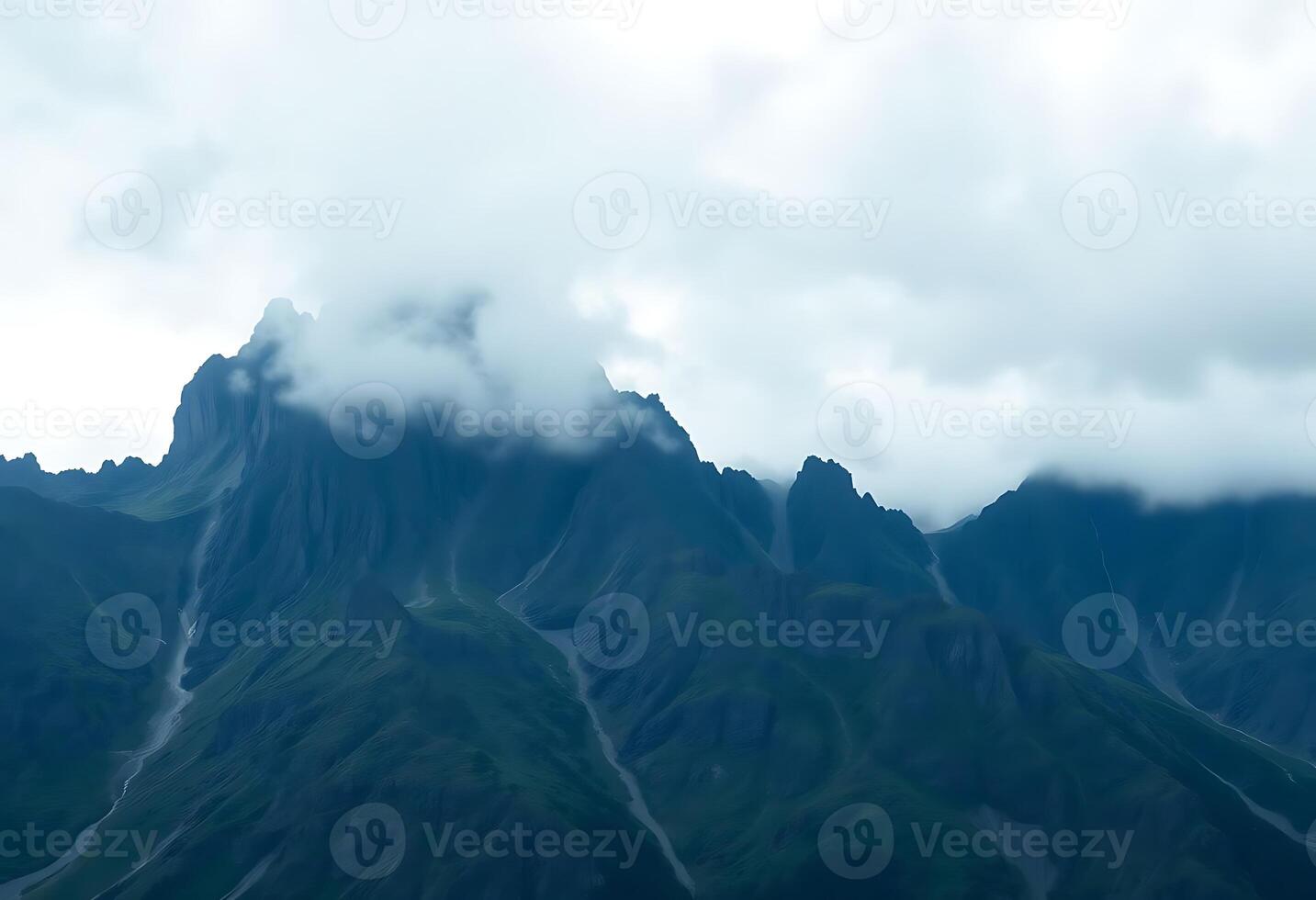 very tall mountain with some clouds in the sky photo