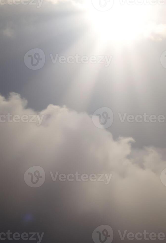 plane flying in the sky with the sun shining through the clouds photo