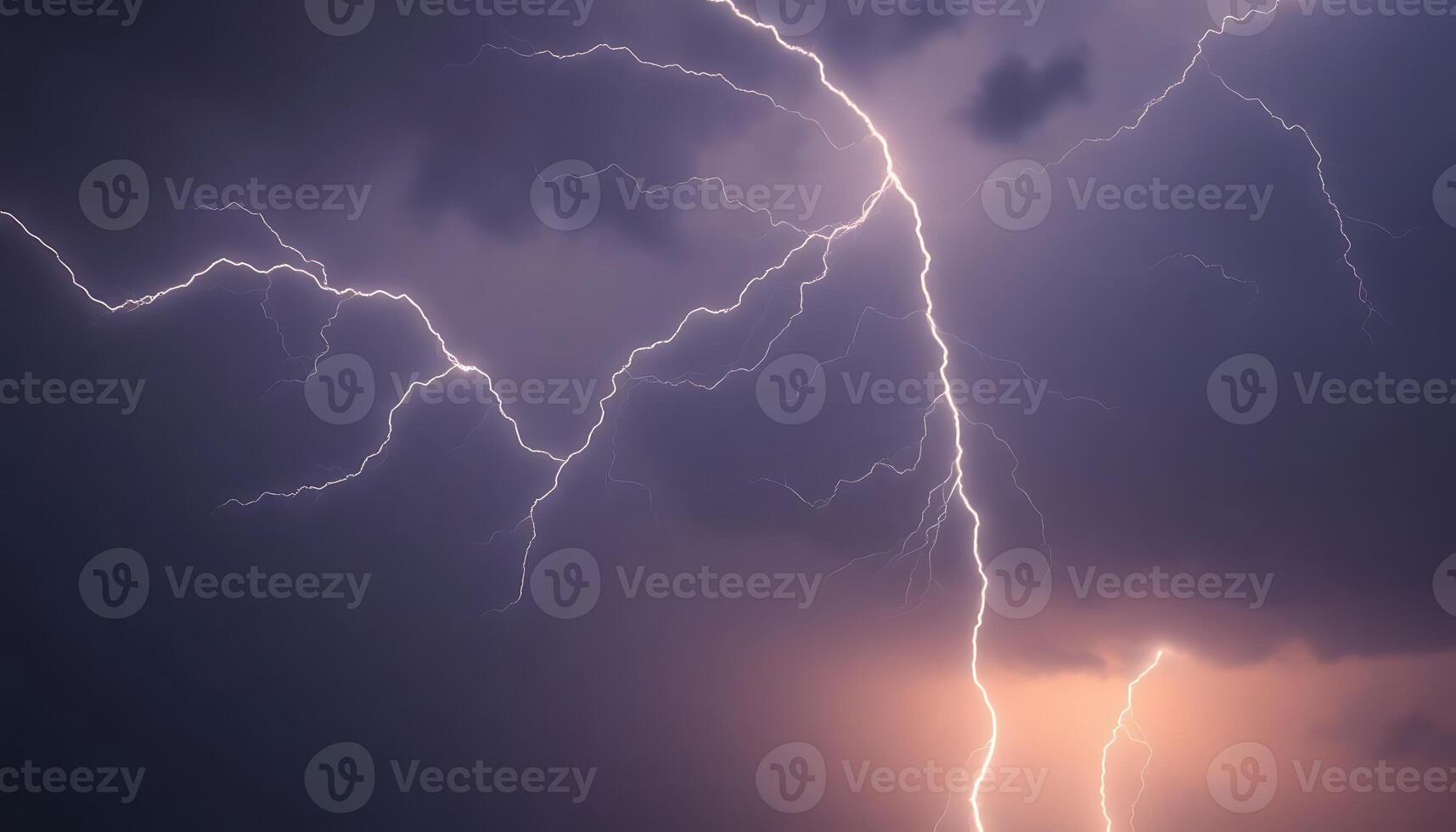Lightning strikes over a dark sky with a few clouds in the background photo