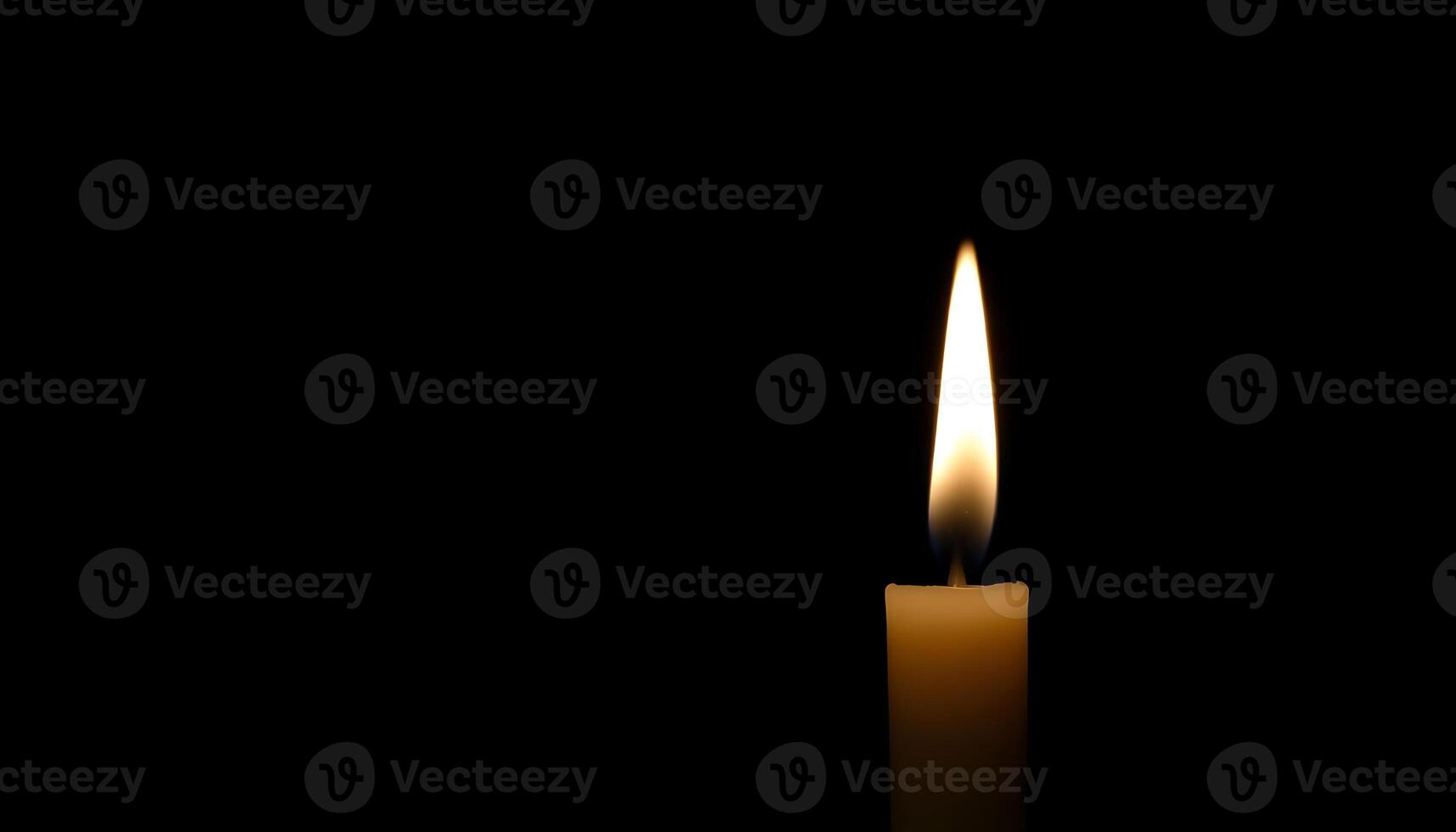 lit candle in the dark on a table photo