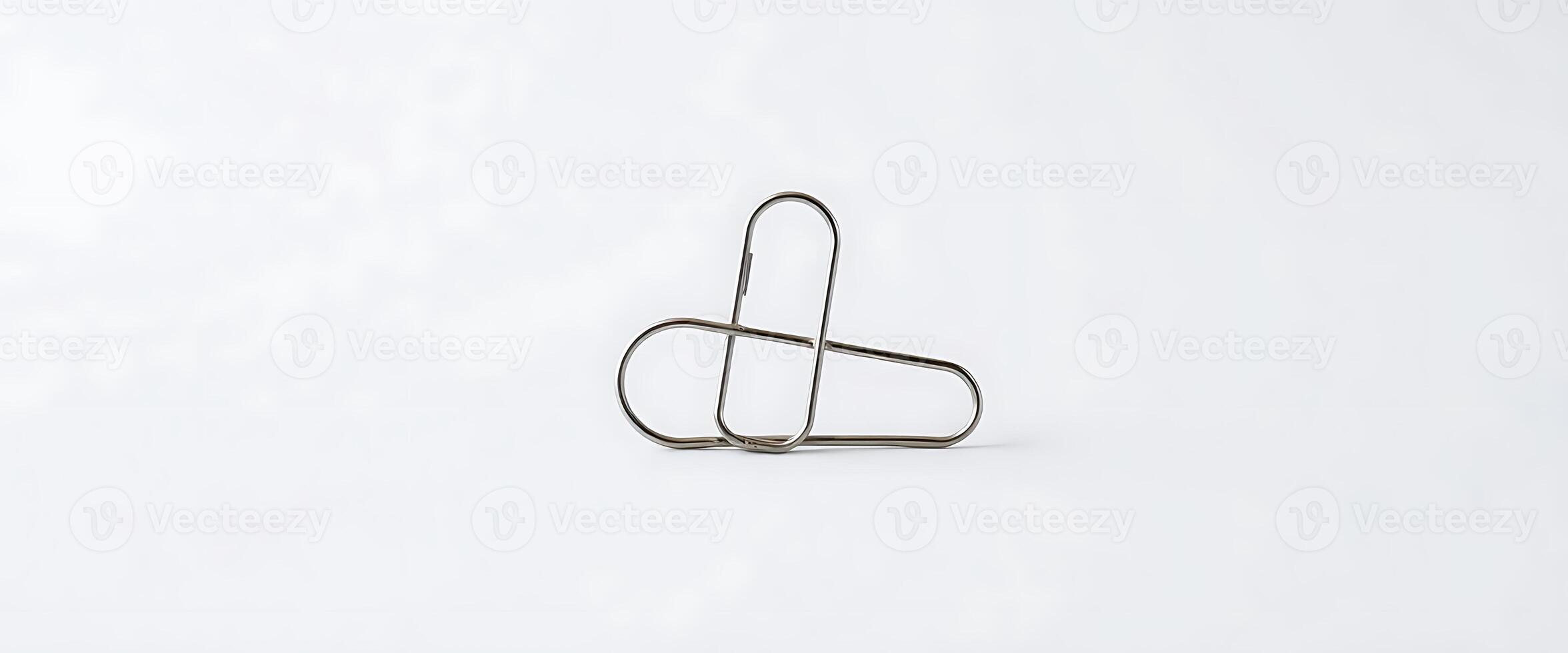pair of metal clips sitting on top of a white surface photo