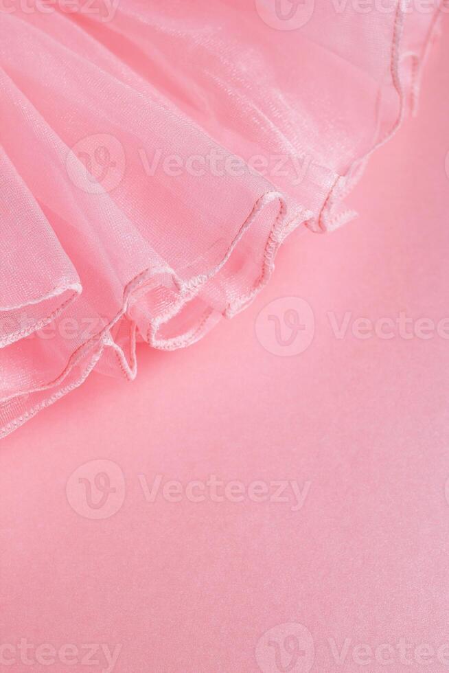 Delicate pink fabric texture with ruffled edge and soft lighting for creative decor with copy space. photo