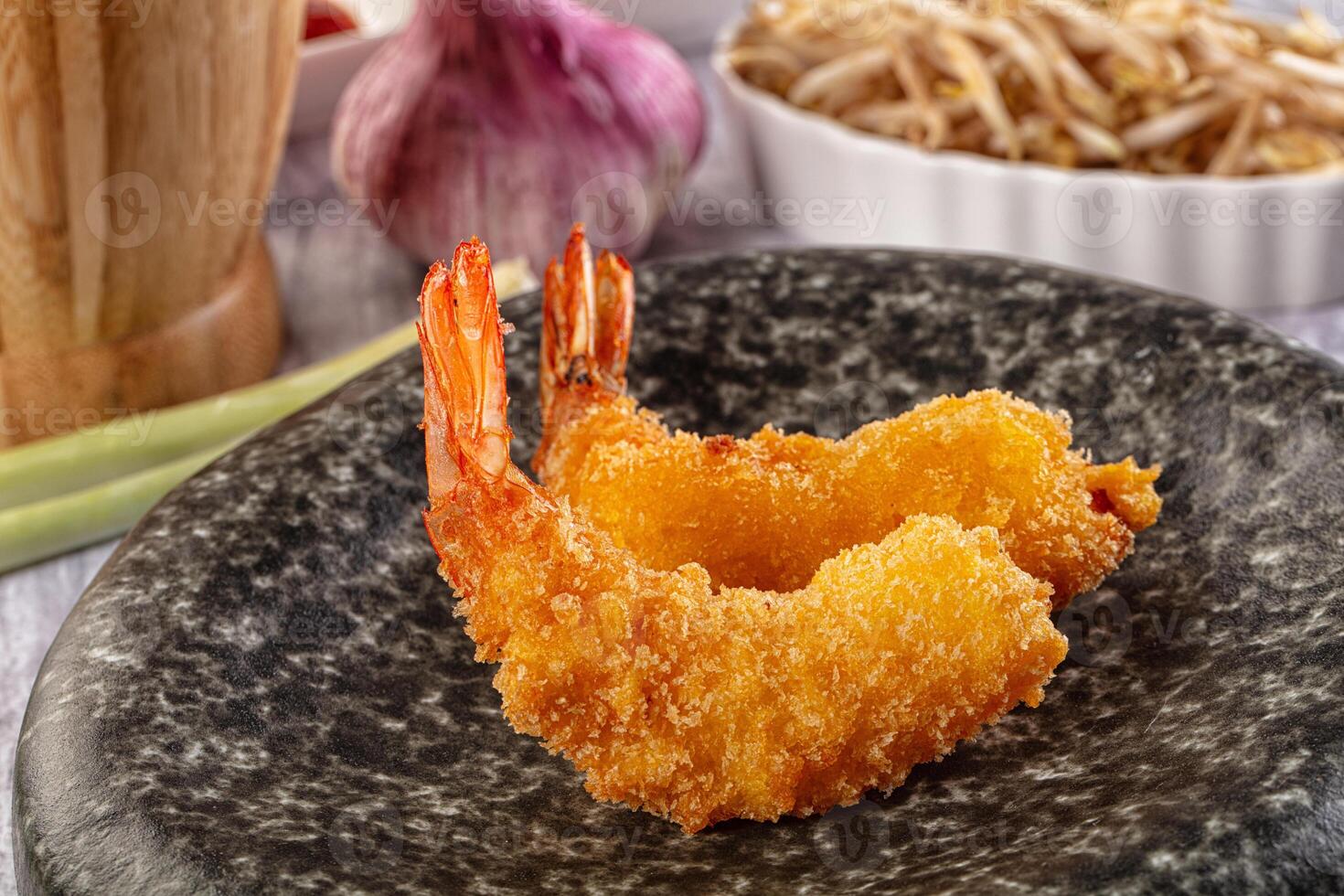 Fried shrimp on a black plate with a bowl of rice photo