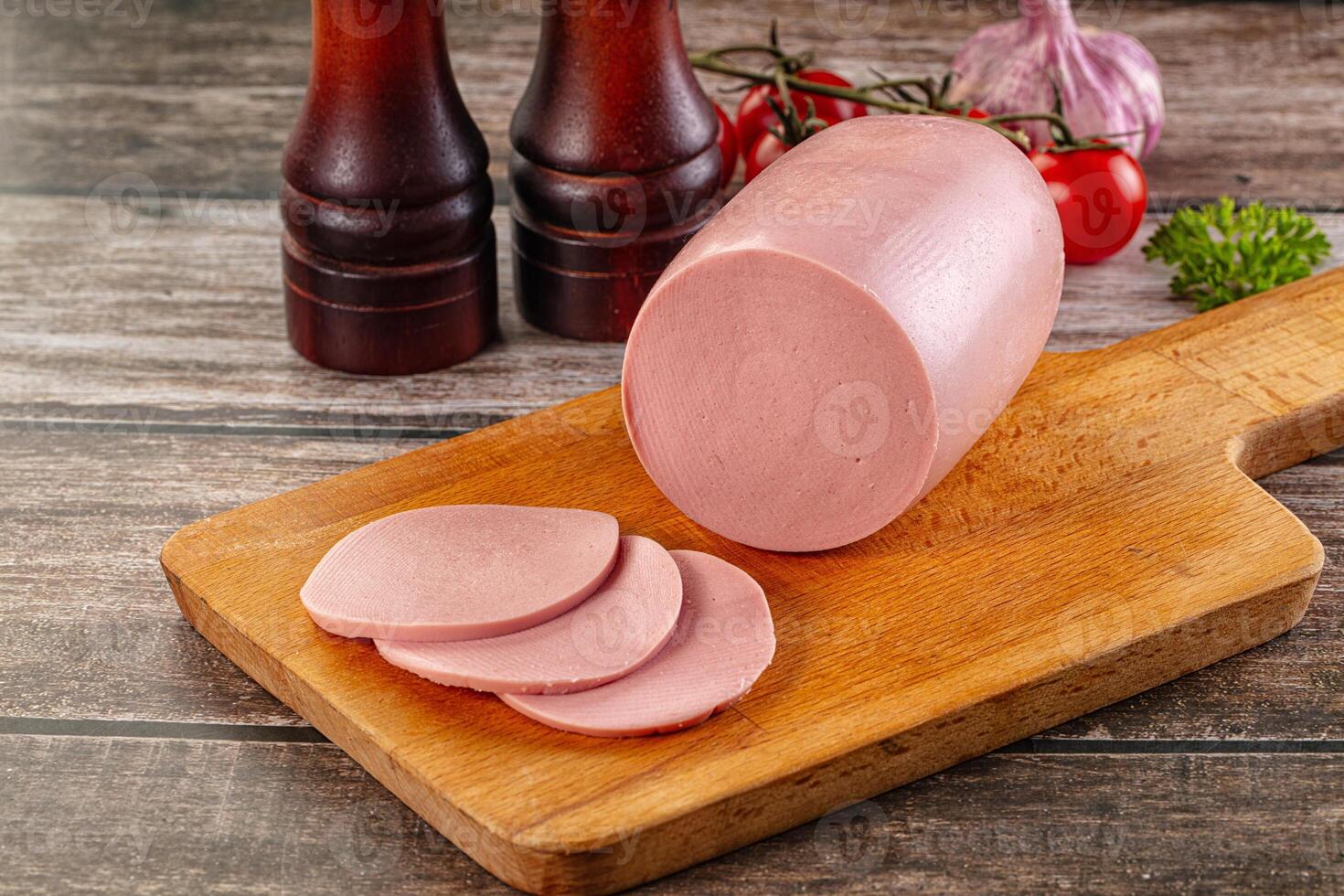A cutting board with a ham on it and some other items photo