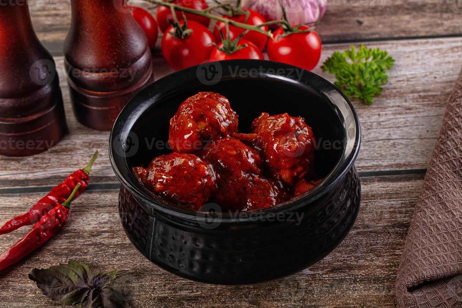 A bowl of chili with tomatoes and peppers on a table photo