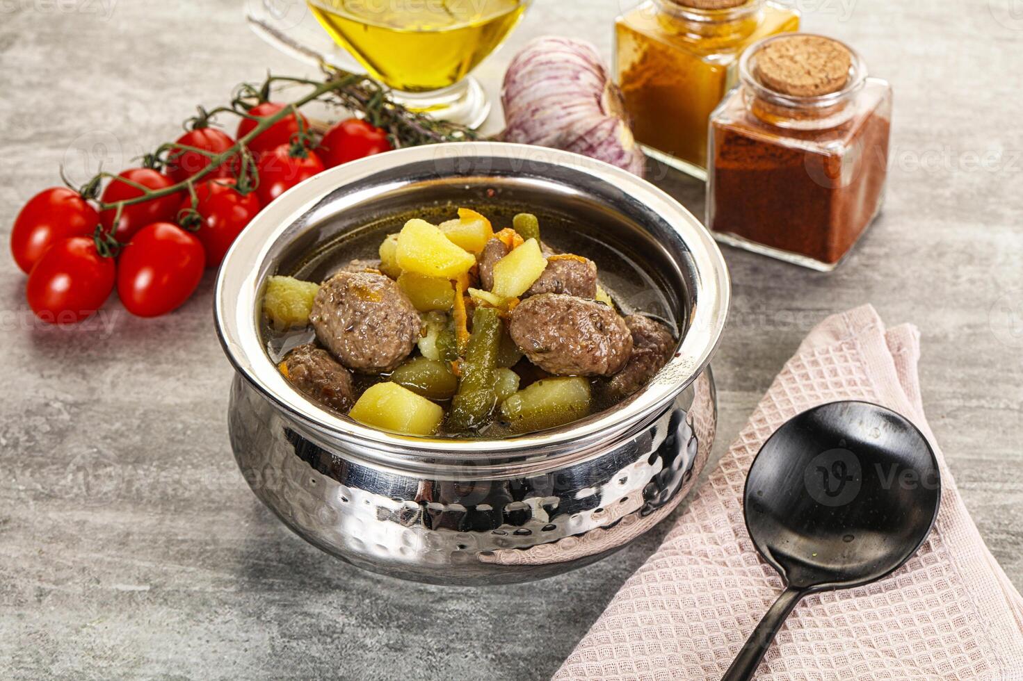 A silver pot with meat, vegetables and spices photo