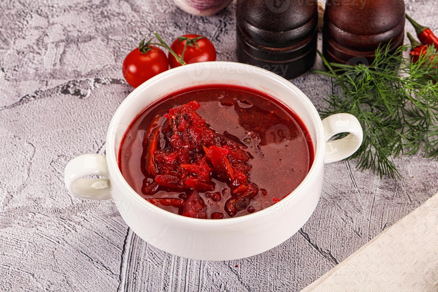 A bowl of red soup with a knife and a spoon photo