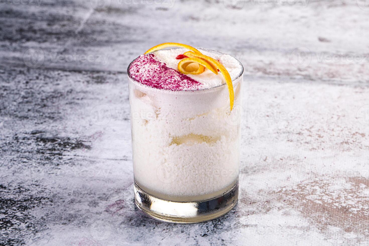 A drink with a white frosting and a red garnish photo