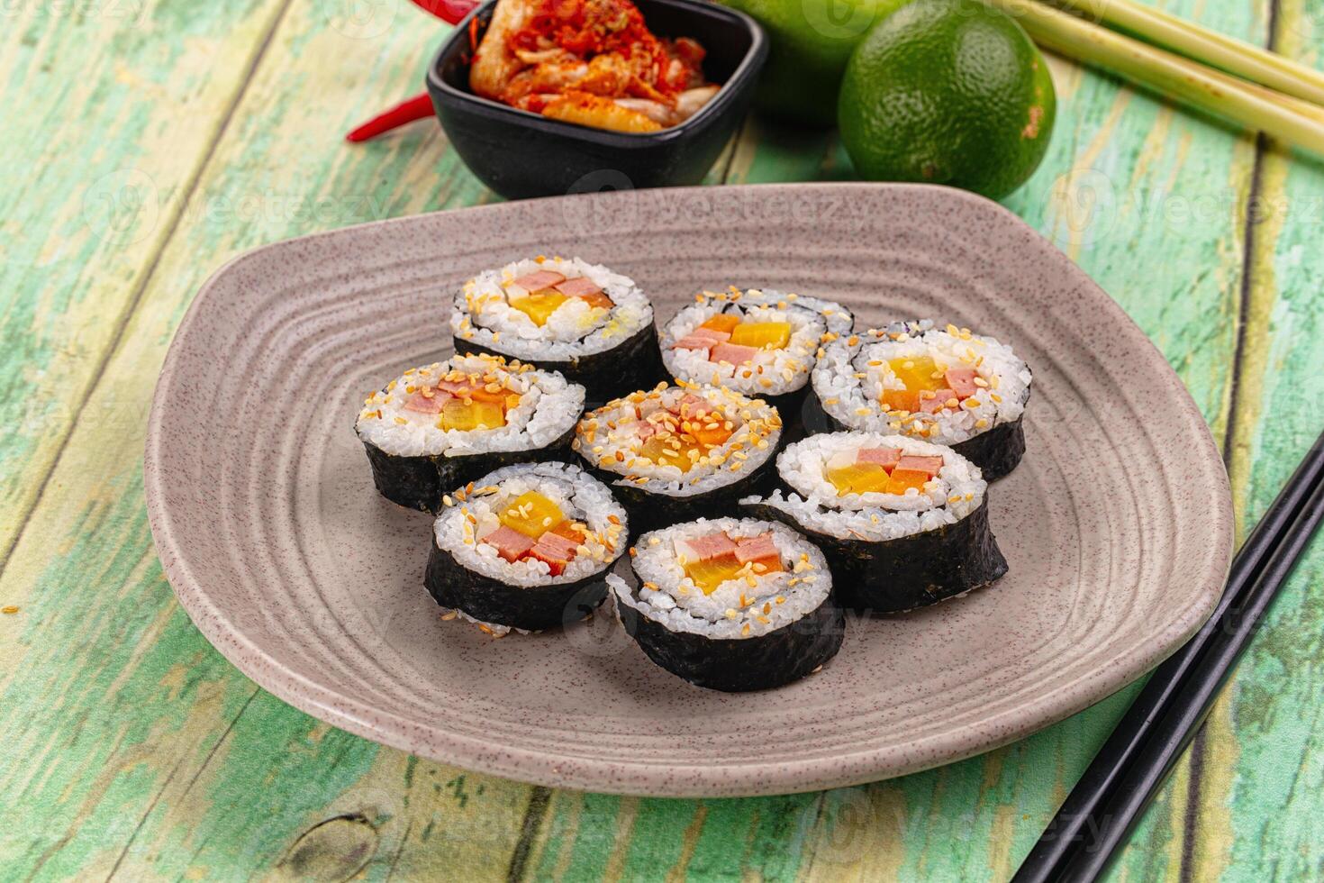 A plate of sushi with chopsticks and other food photo
