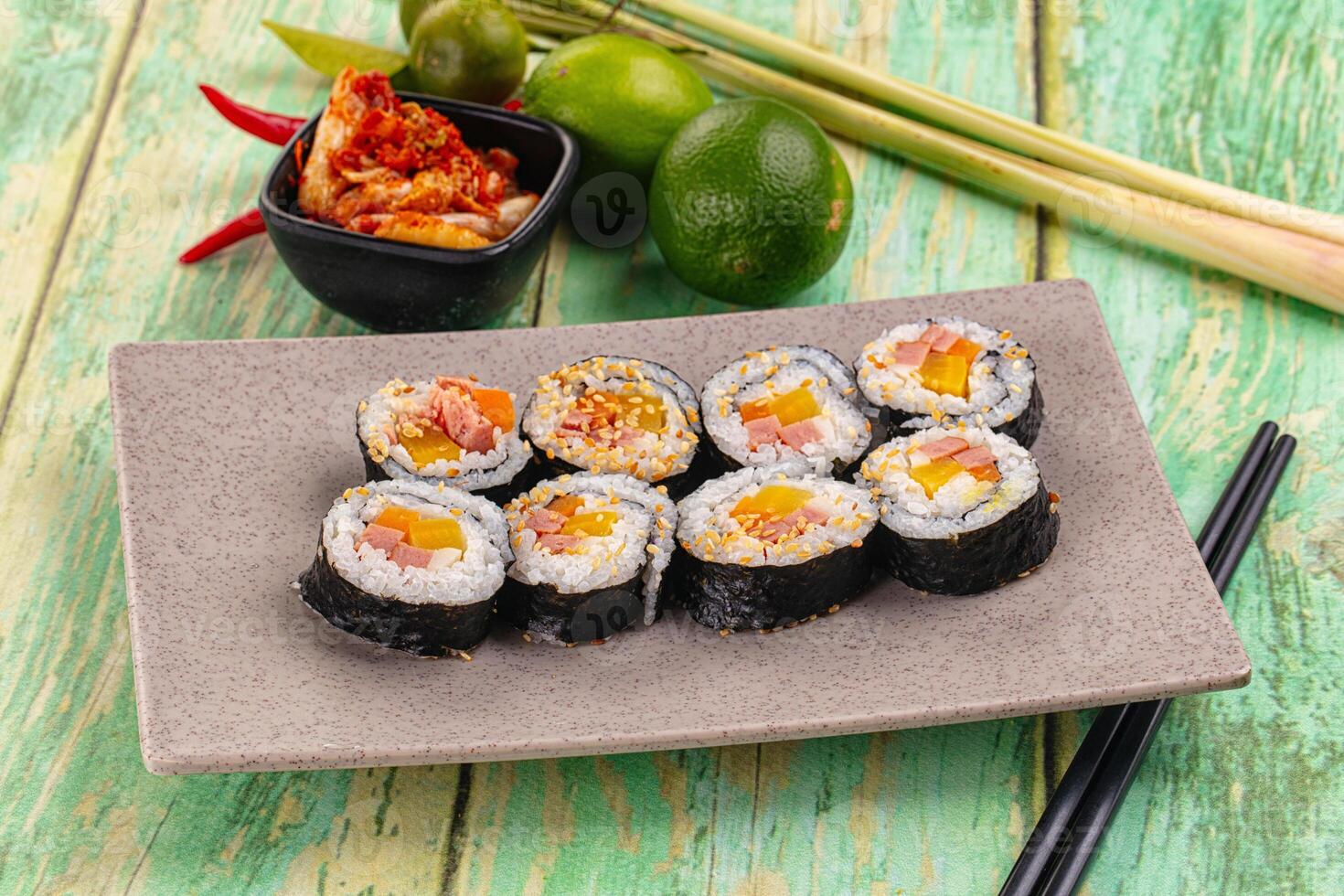 Sushi rolls on a plate with chopsticks and other ingredients photo