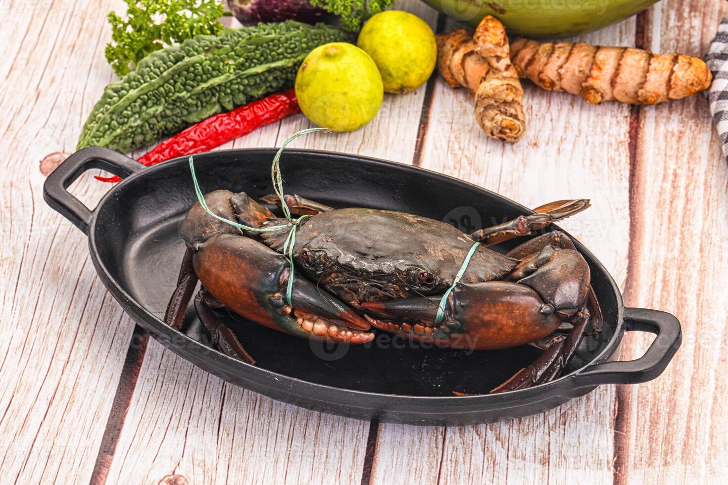 A crab in a pan with vegetables and other food photo