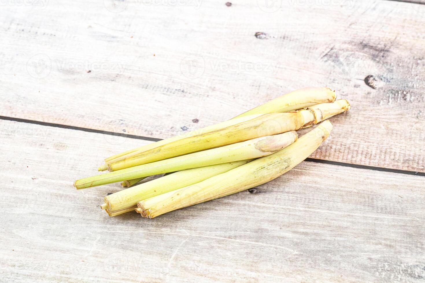 A pile of fresh green stalks on a wooden surface photo