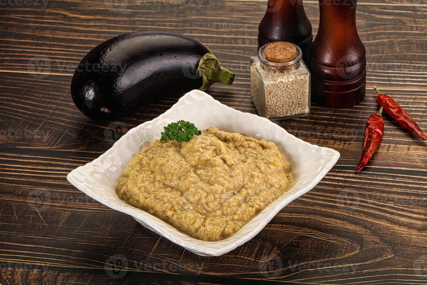 A bowl of hummus with eggplant and spices photo