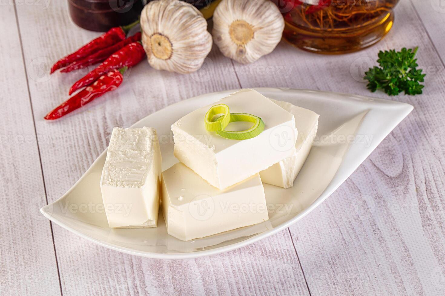 A white plate topped with cubes of tofu and garlic photo