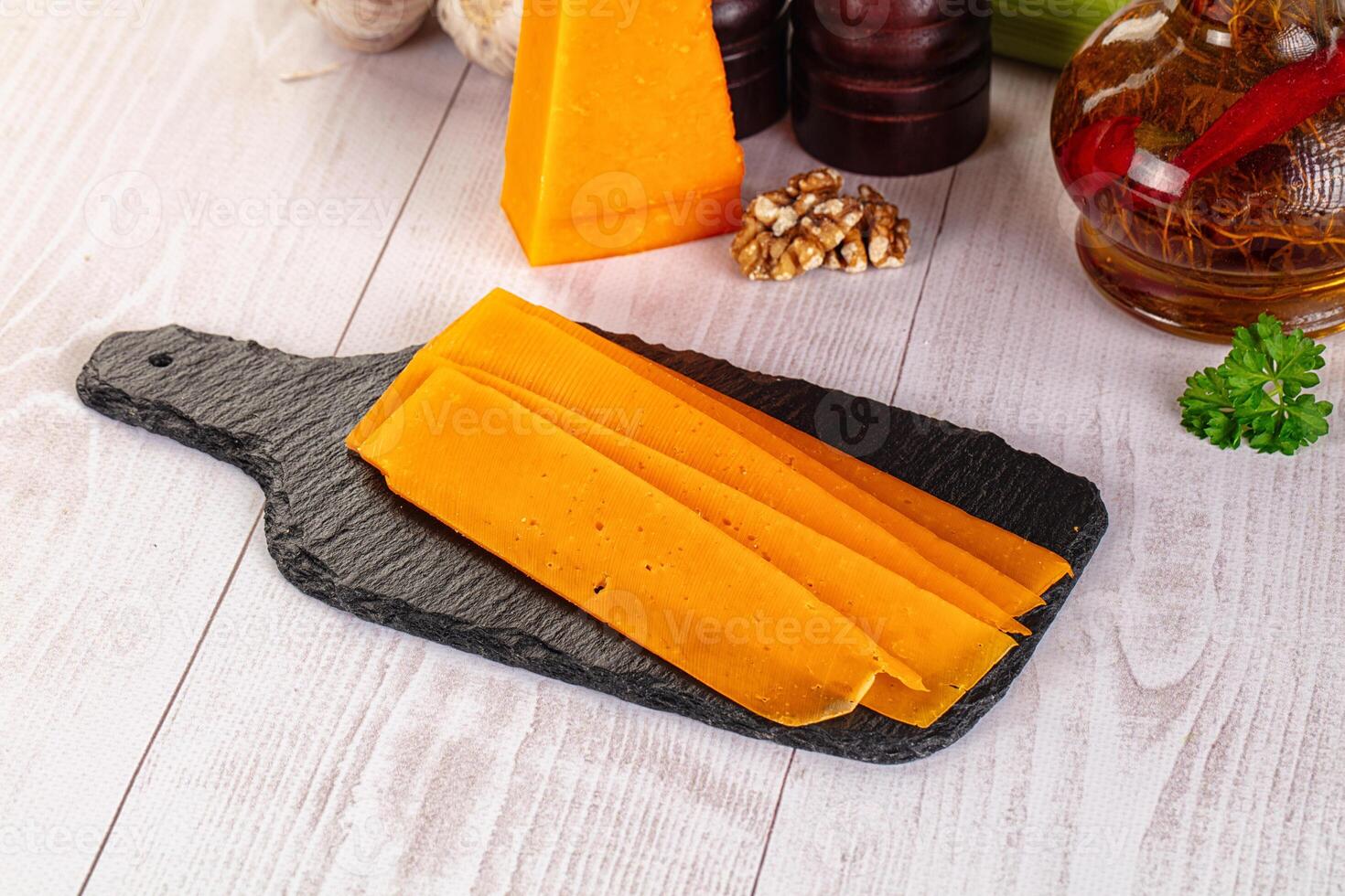 A cutting board with cheese slices on it photo