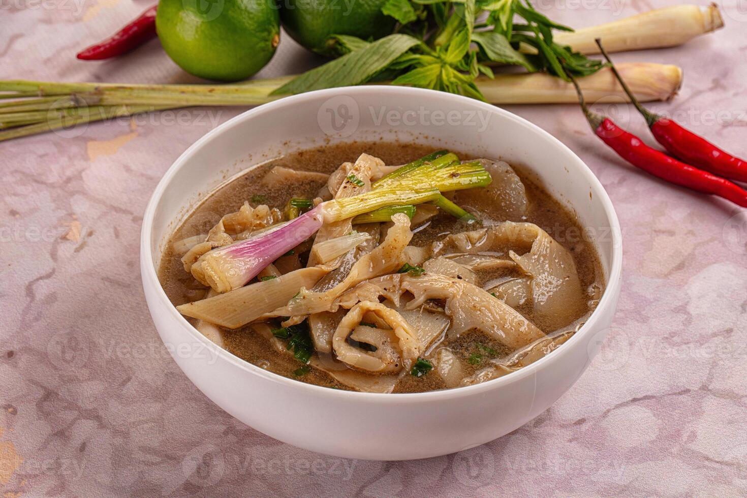 A bowl of soup with vegetables and a chili pepper photo