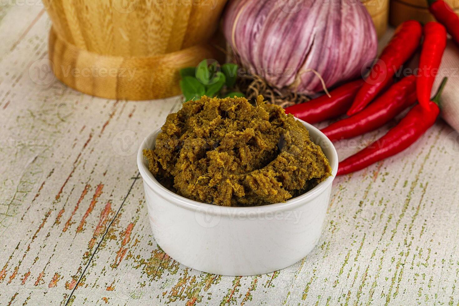 A bowl of green paste with spices and herbs photo
