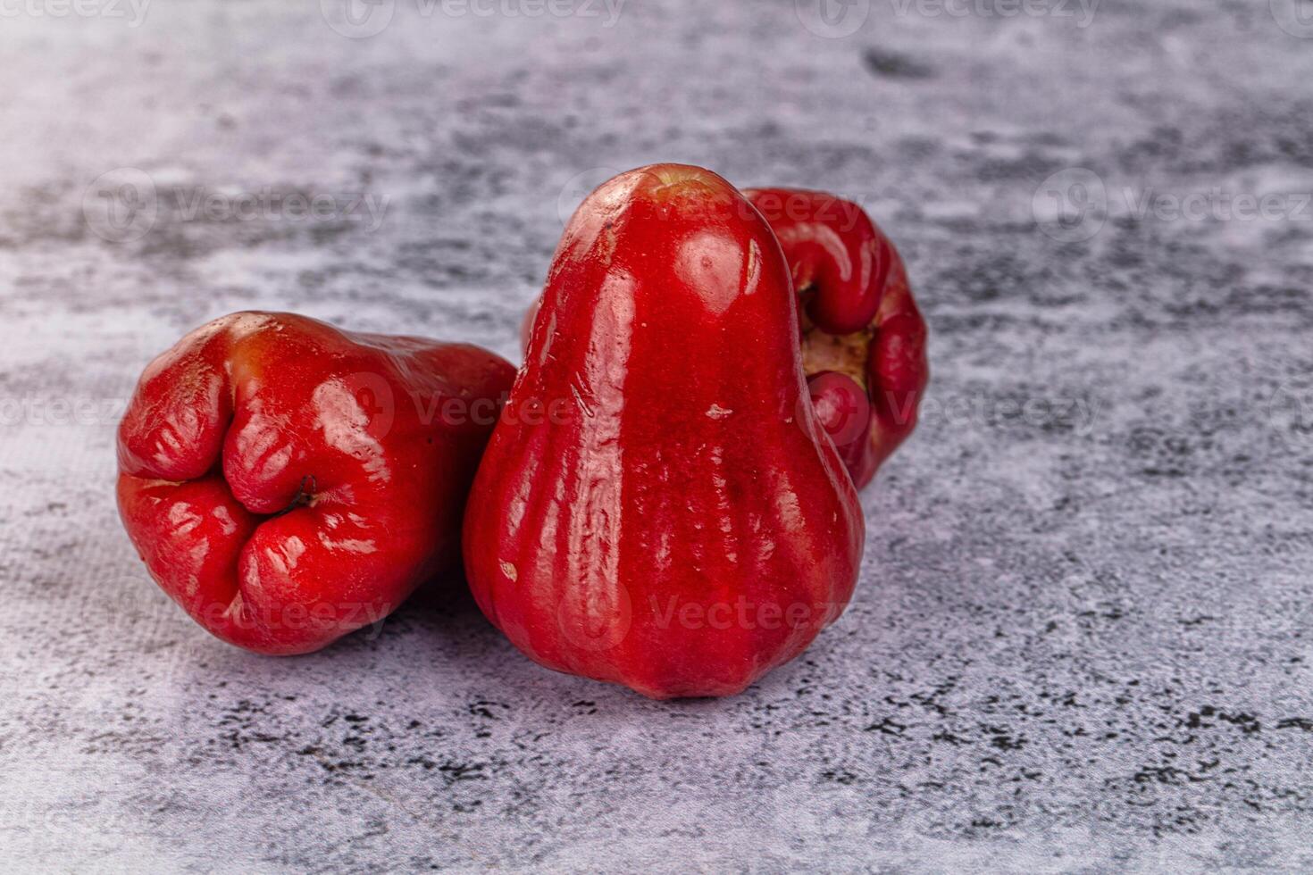 Three red apples on a gray background photo