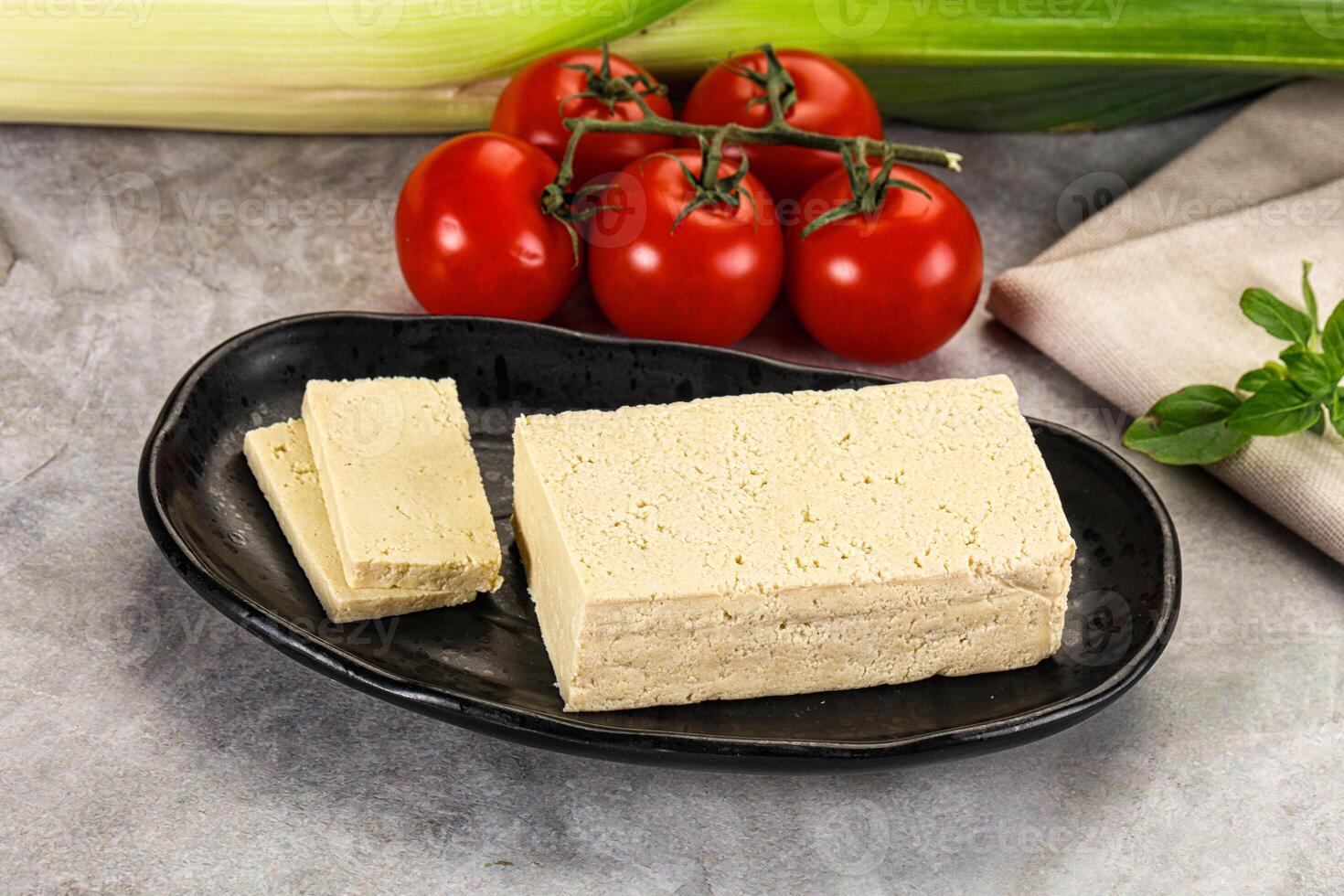 A plate with a piece of tofu and tomatoes photo