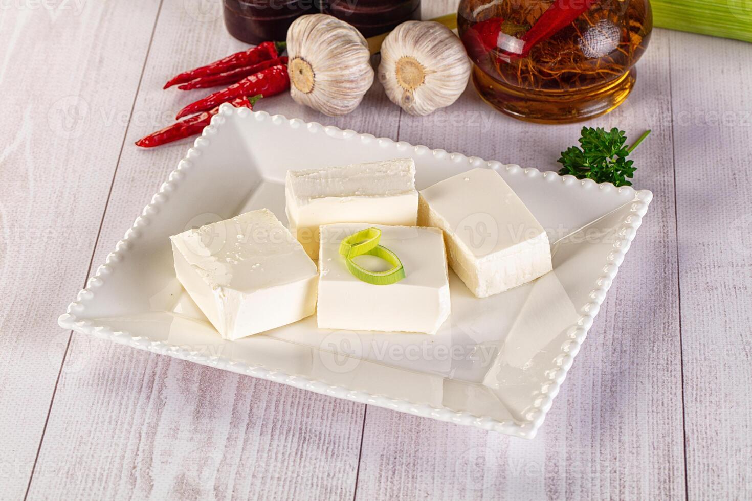 A white plate with cubes of tofu, garlic, and other ingredients photo