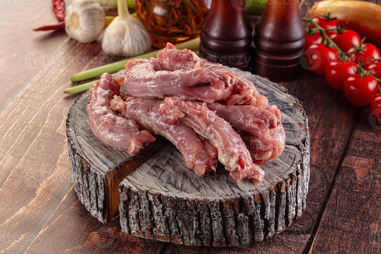 Raw meat on a wooden table with vegetables and other ingredients photo