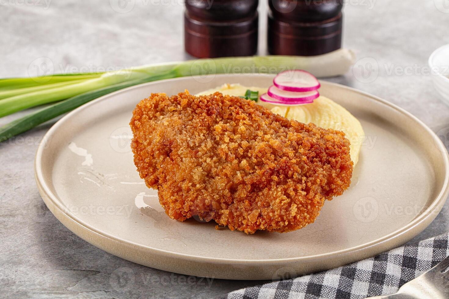 A plate with a fried chicken and mashed potatoes photo