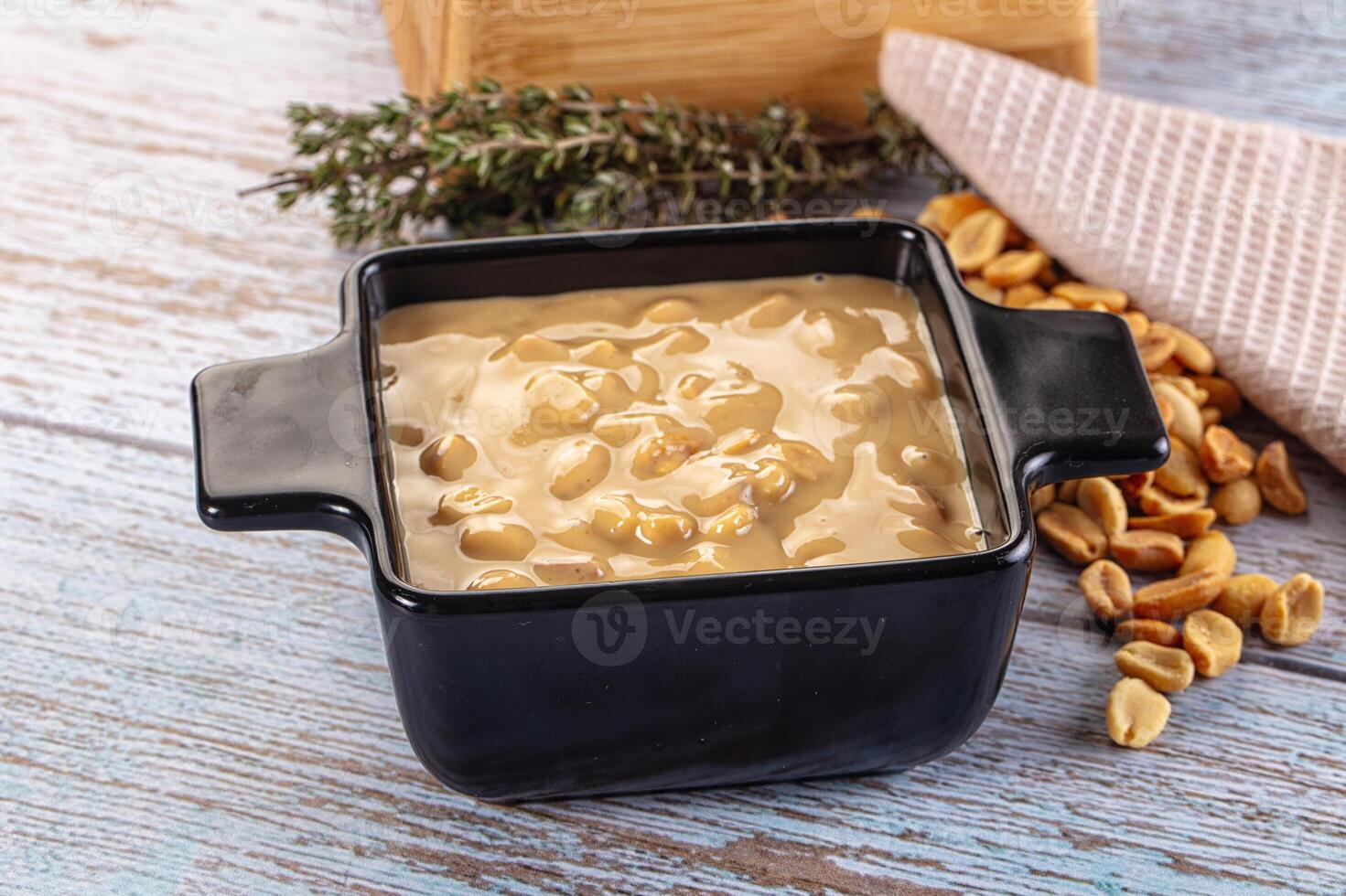 Peanut butter in a black dish on a wooden table photo