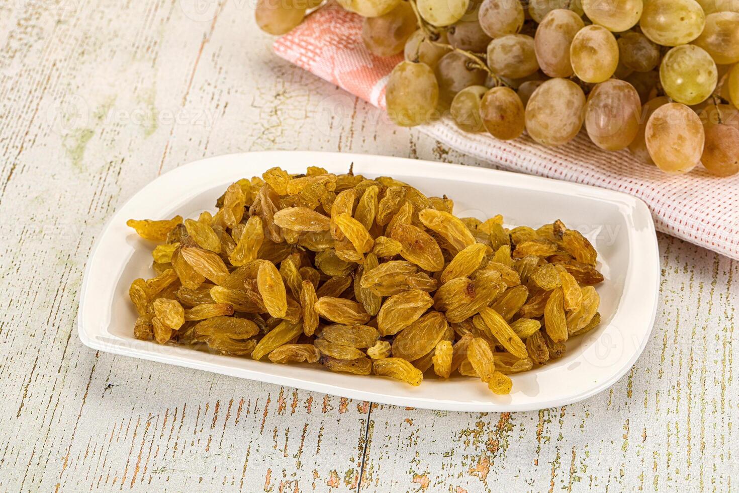 A white plate with raisins and grapes photo