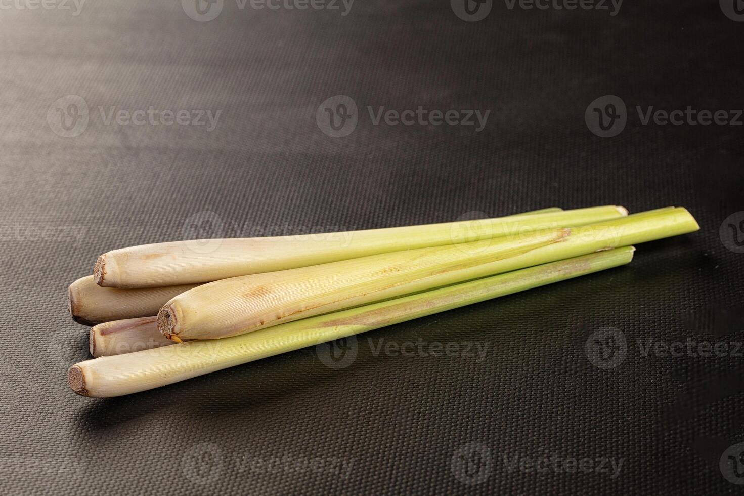 Three long pieces of green stalks on a black surface photo