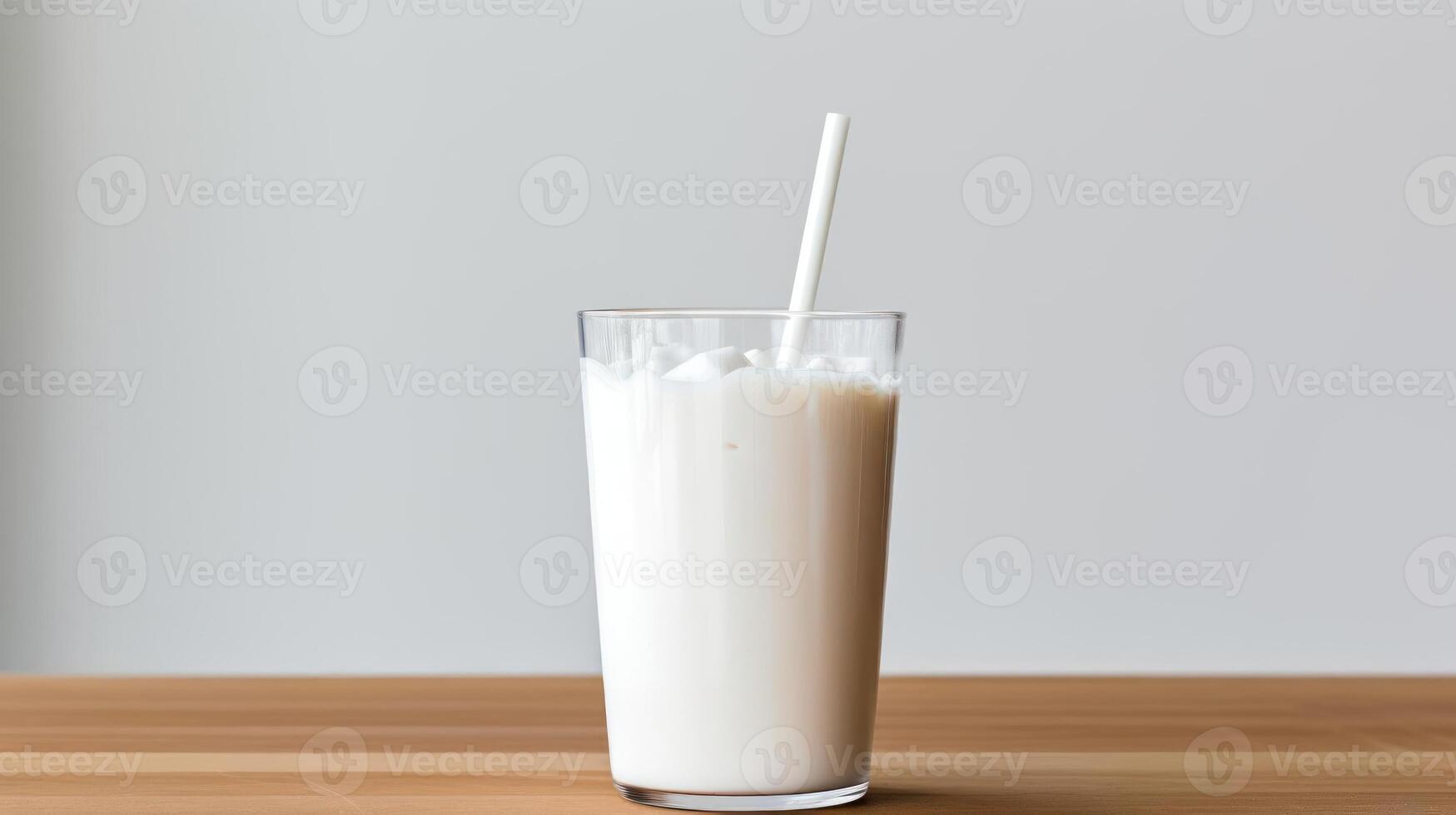 A tall glass of milk with a straw. photo