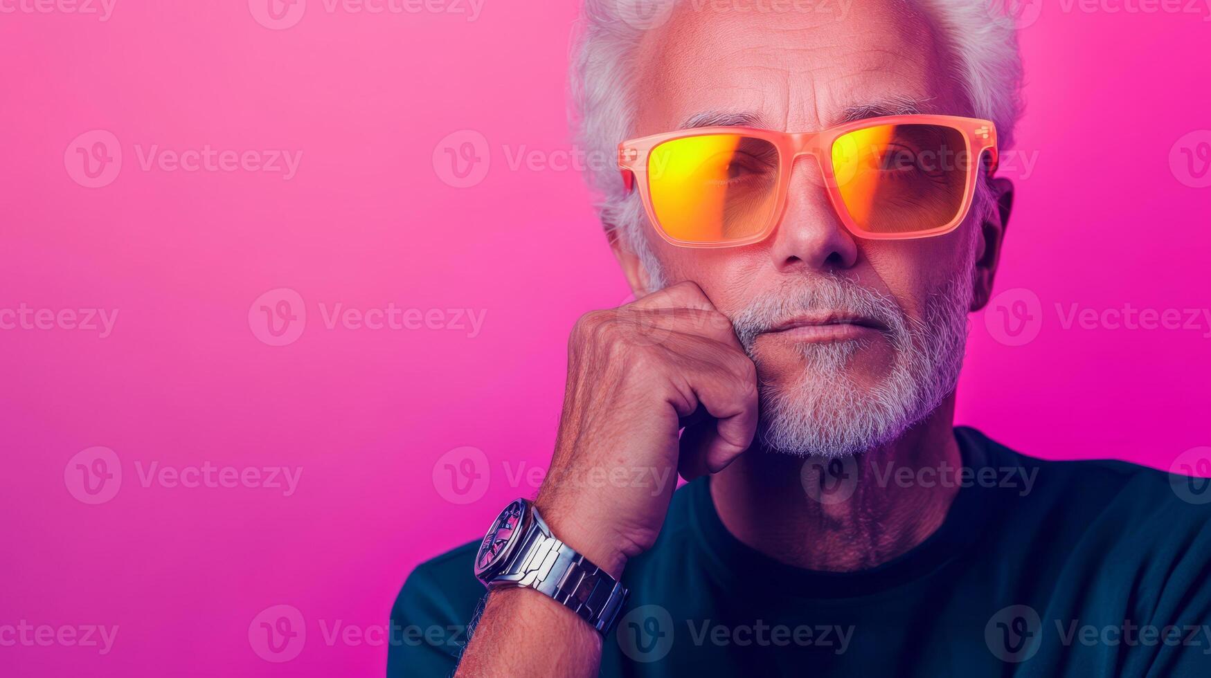 An elderly man in neon glasses and a metallic watch poses against a vibrant purple backdrop photo