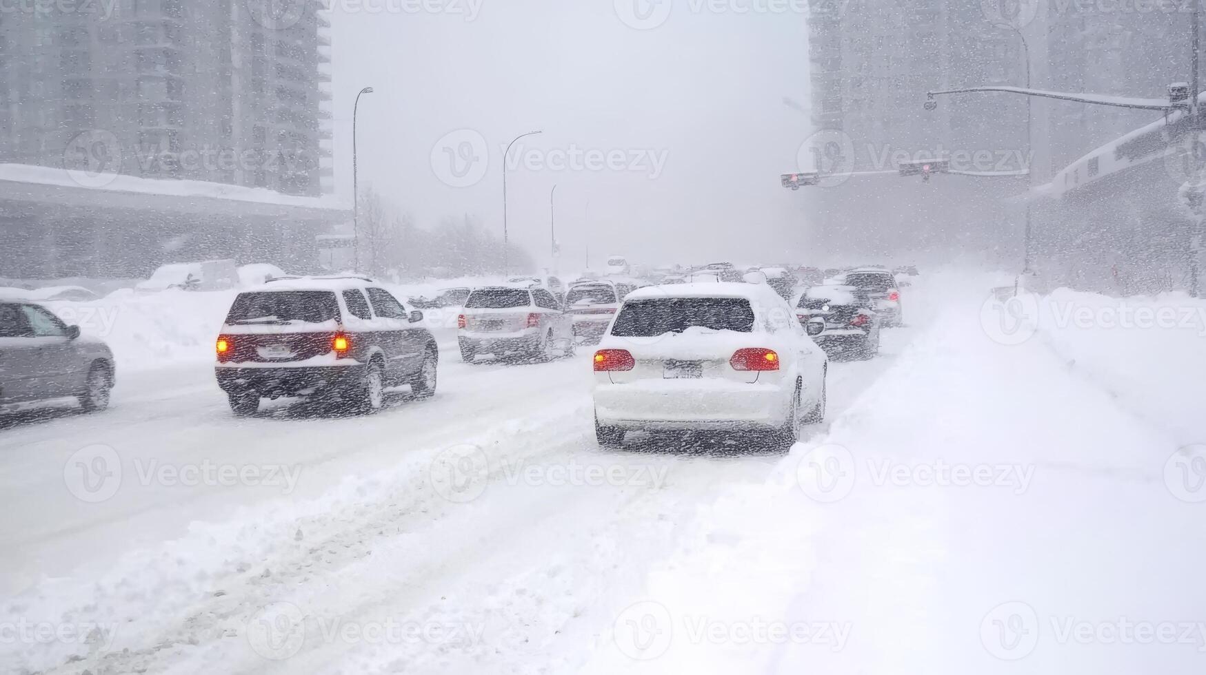 Traffic jams form as cars navigate through deep snow in a winter storm on a busy urban highway photo