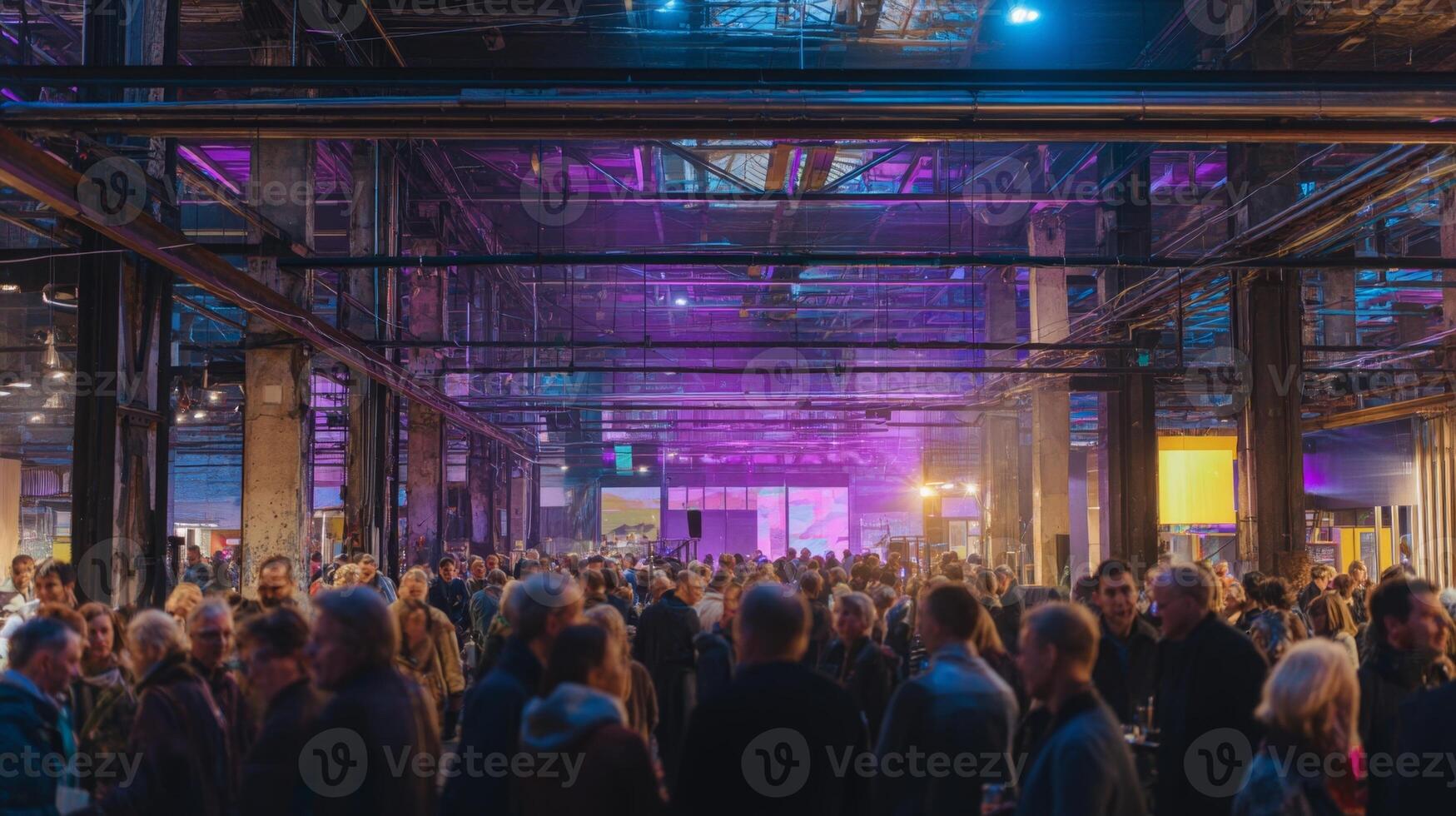 Attendees engage in a lively cultural event in a transformed industrial space filled with color photo