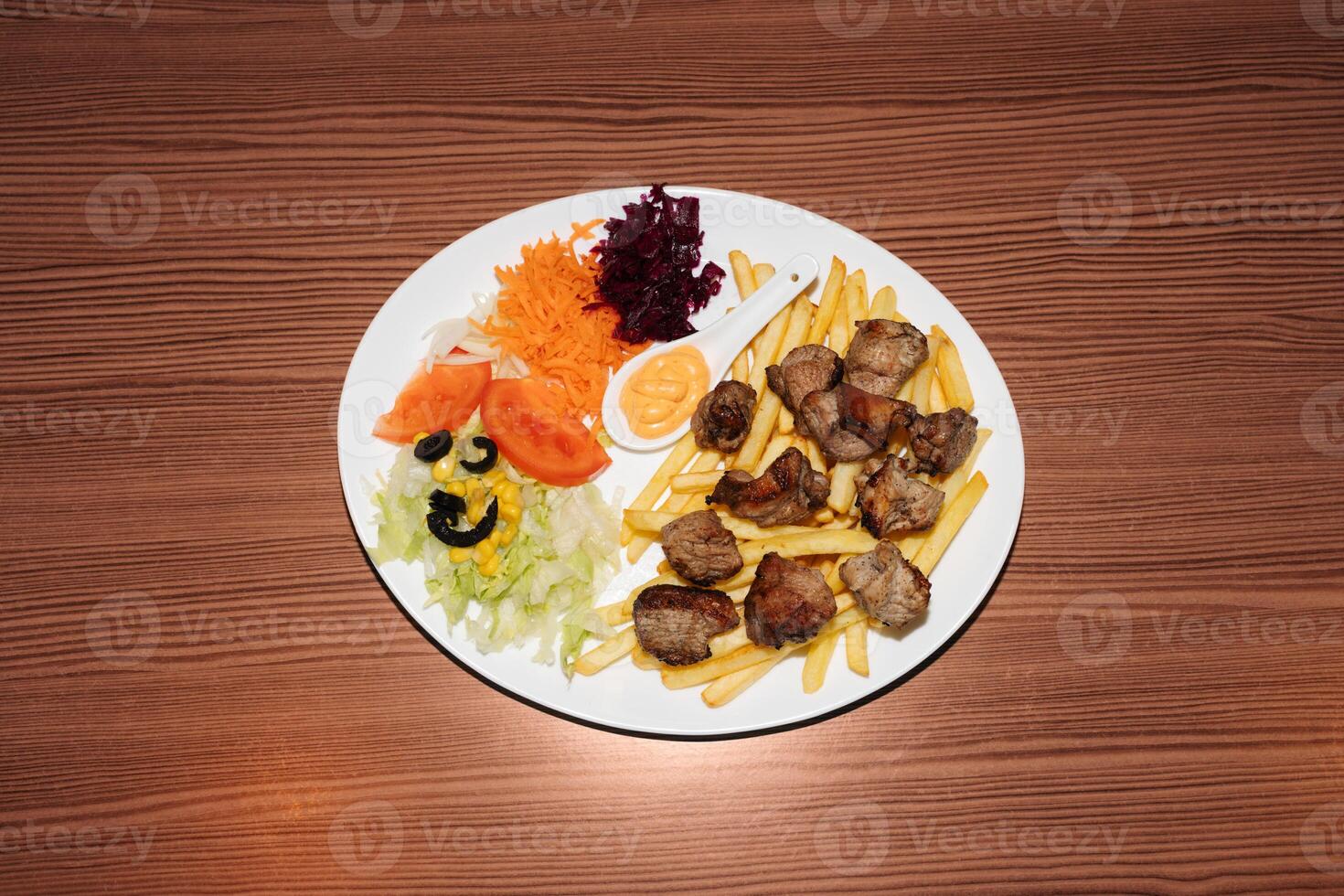Turkish kebab plate with fries, vegetables and pork photo
