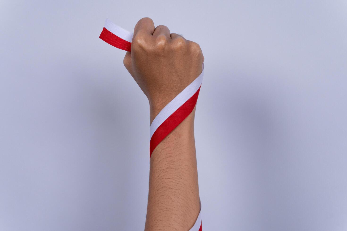 Hand Fist Holding a Red and White Ribbon, Indonesian Independence Day Concept and Hands Clenched photo