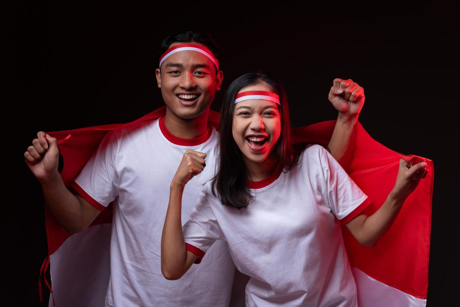 Portrait of Young Asian Man and Woman with Red White Indonesian Flag Celebrating Independence Day photo