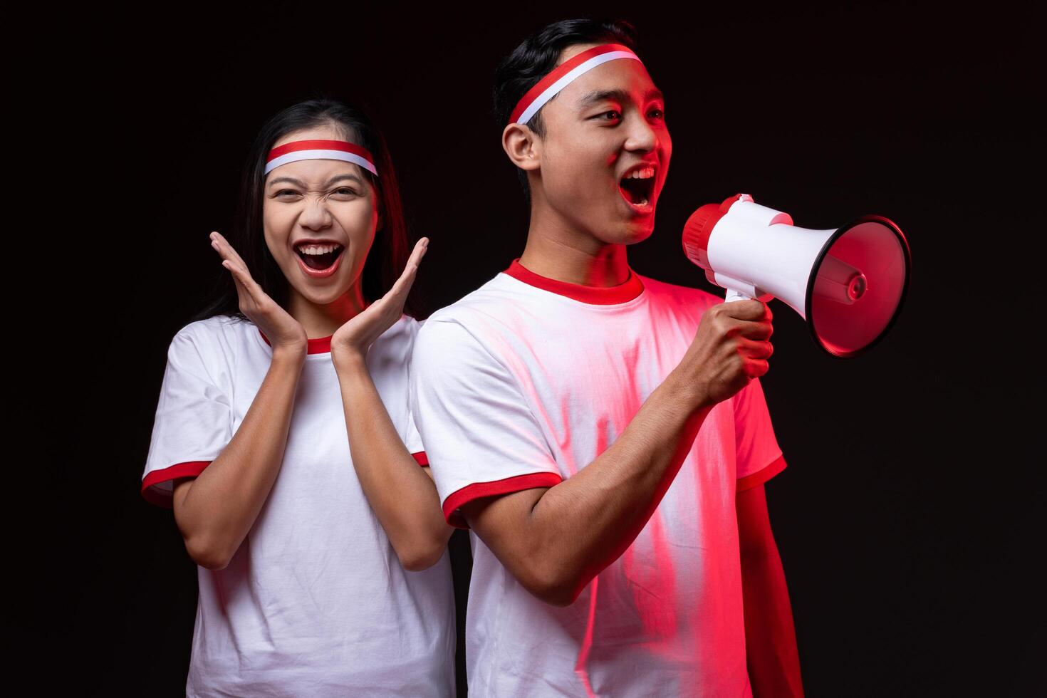 Portrait of Young Asian Man and Woman with Megaphone Wearing Red White Outfit, Indonesian Independence Day Concept photo